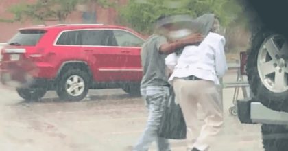 Teenager gets praised by cop after helping an old lady through the rain.