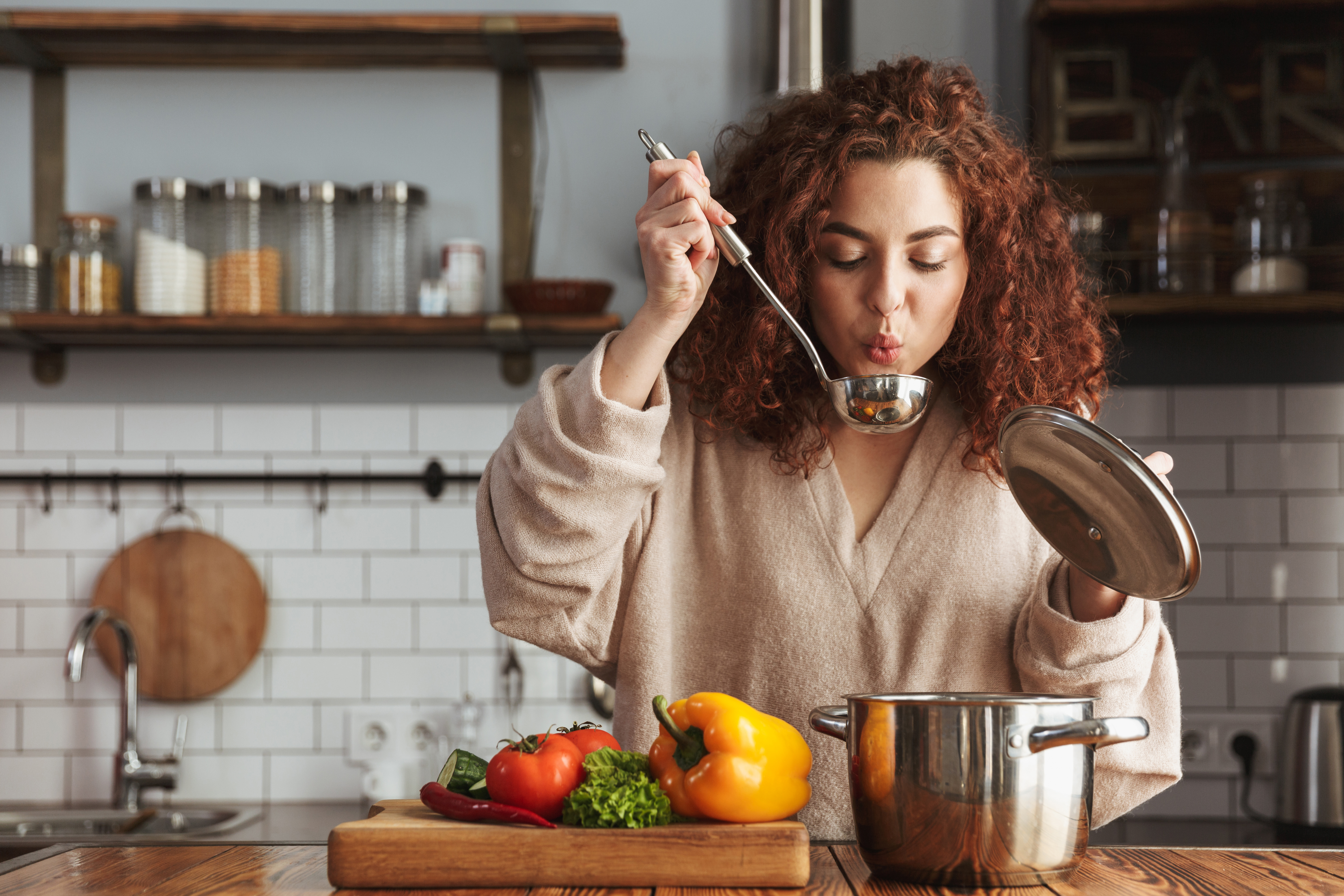 A woman tasting the food she has cooked | Source: Shutterstock