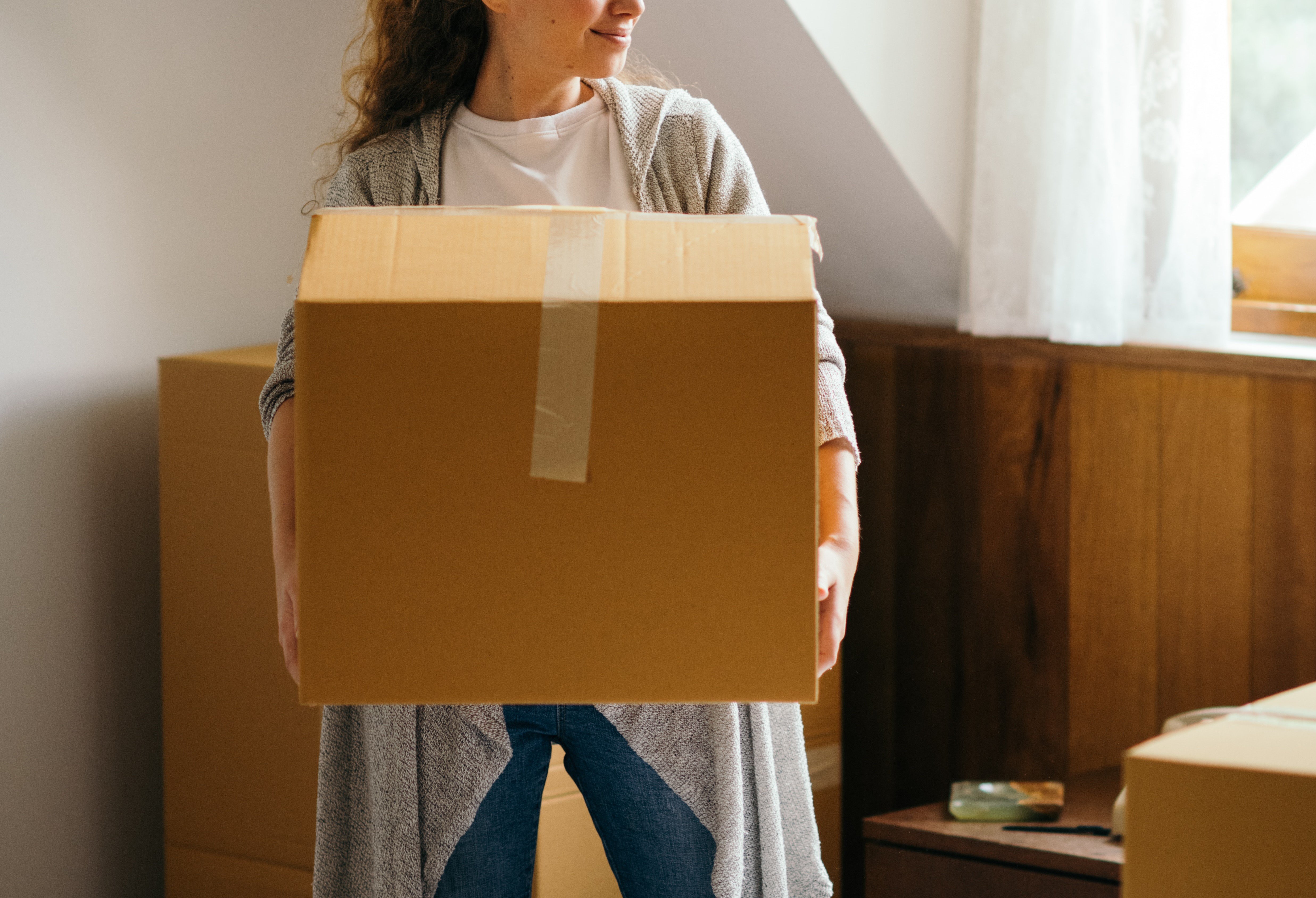 A woman holding a cardboard box | Source: Pexels