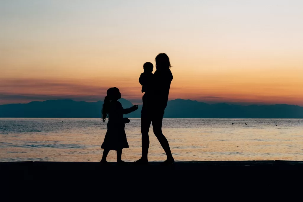 A woman with two children at the beach | Source: Unsplash