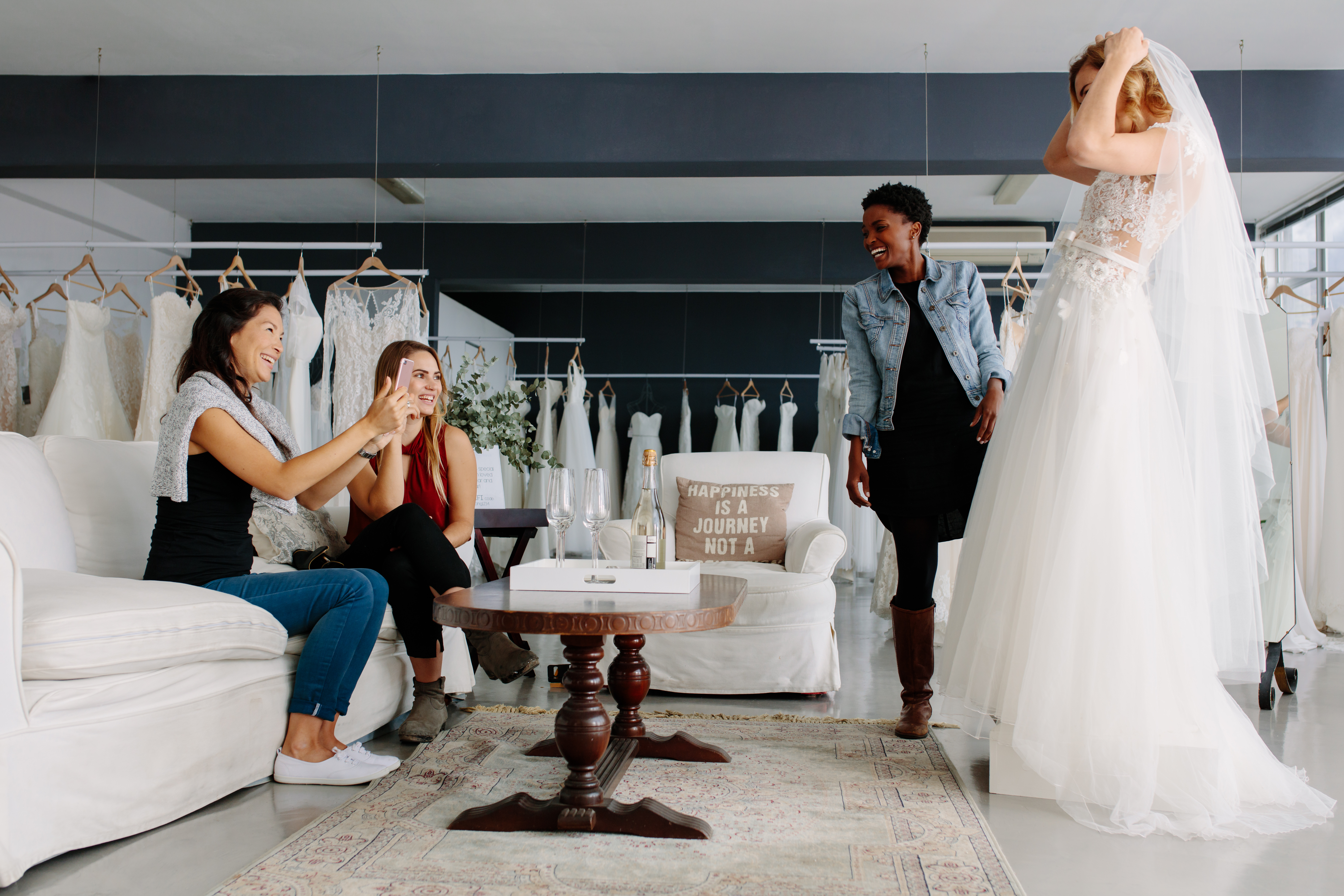 A woman trying on a wedding dress surrounded by her friends | Source: Shutterstock