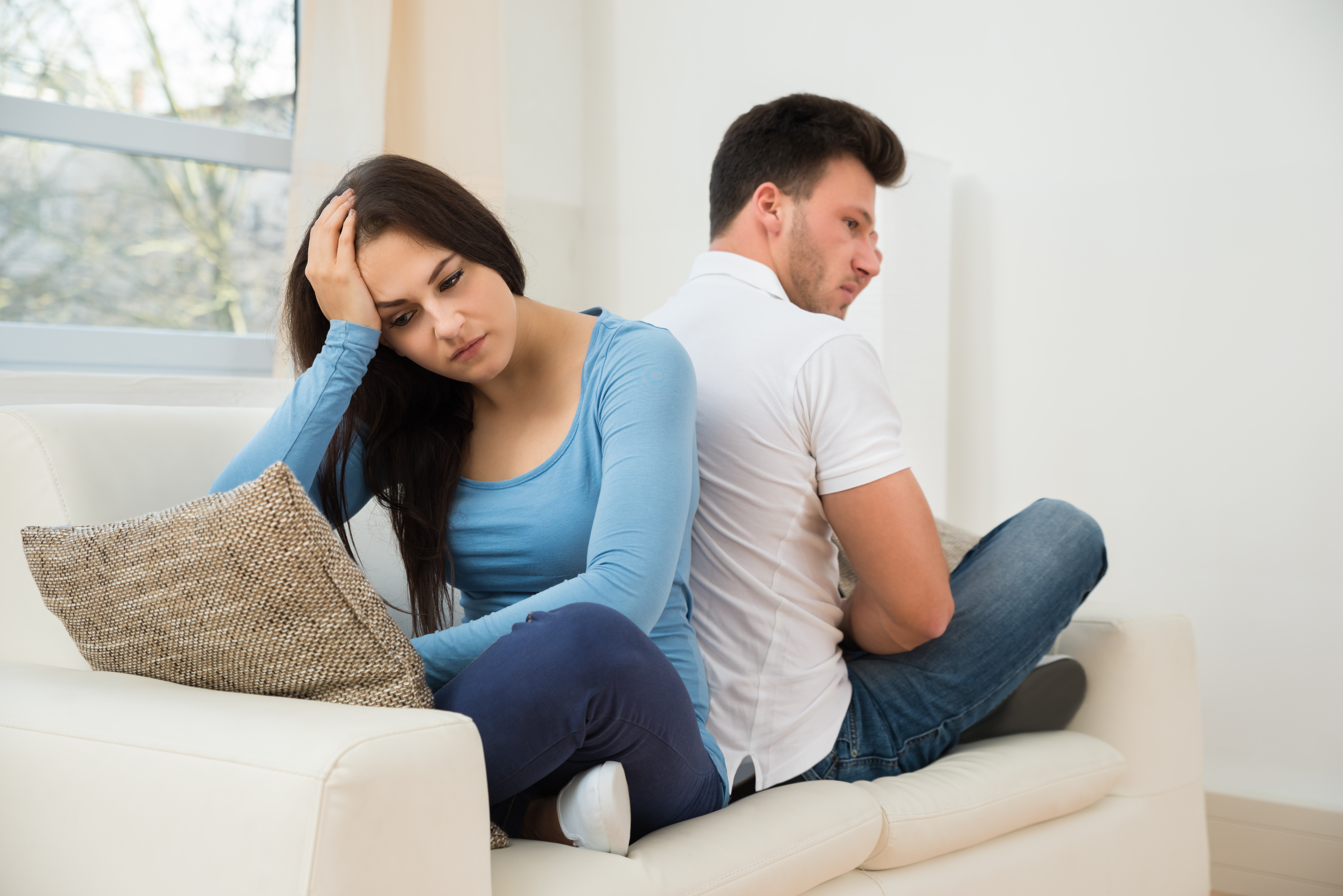 Man and woman back to back on a couch not talking | Source: Shutterstock
