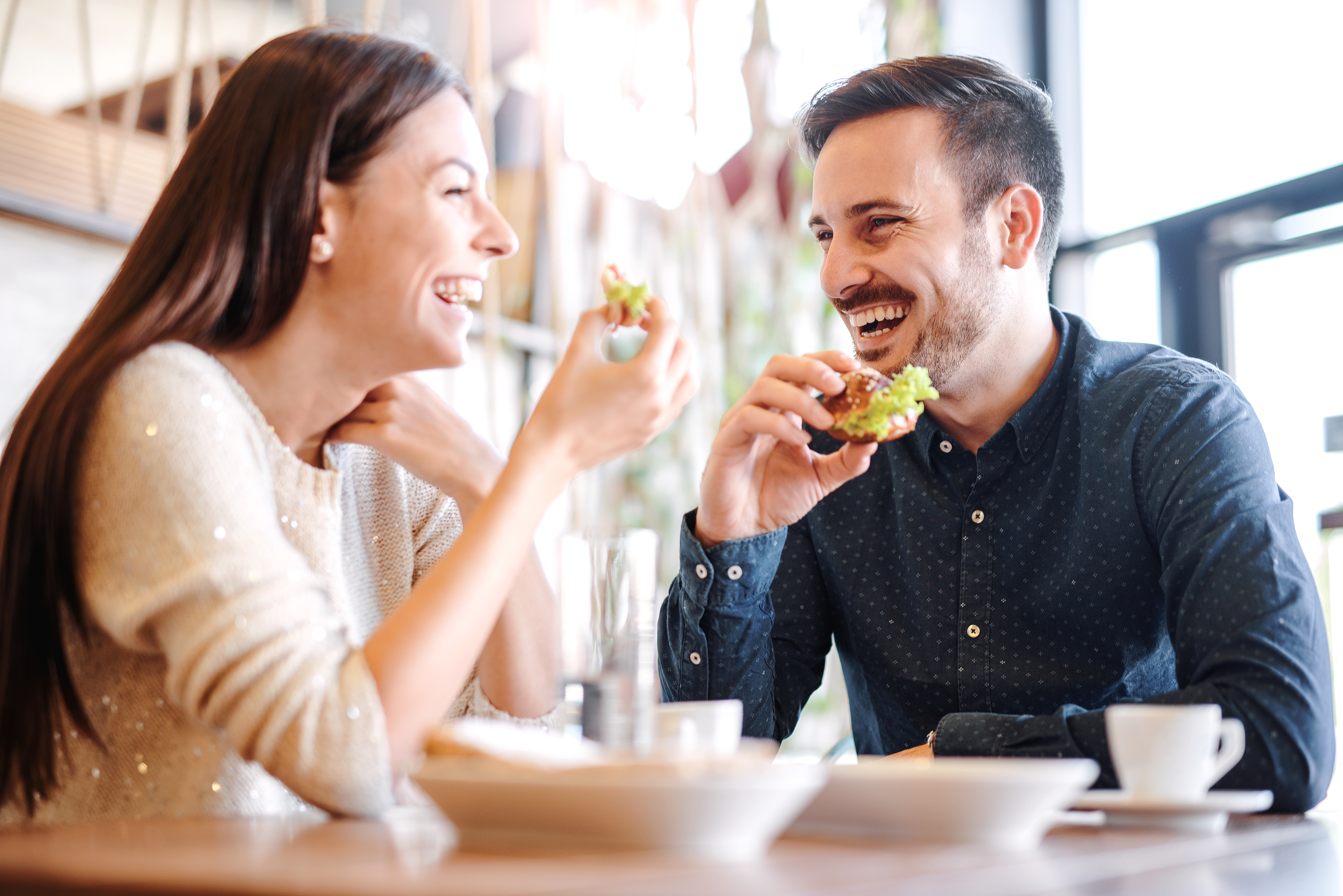 A happy couple enjoying food in a cafe | Source: Shutterstock