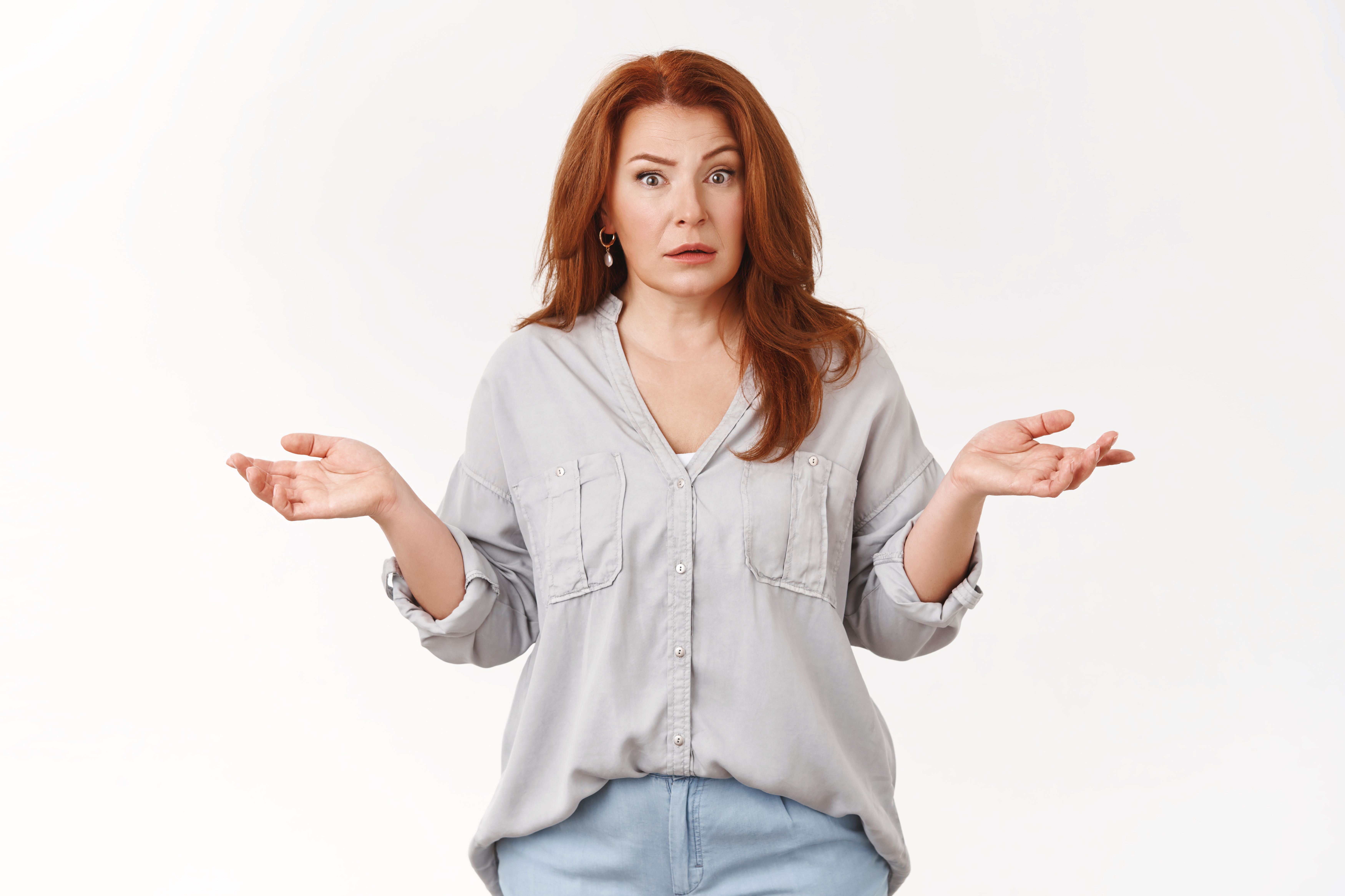 A confused woman with her hands pointed up | Source: Shutterstock
