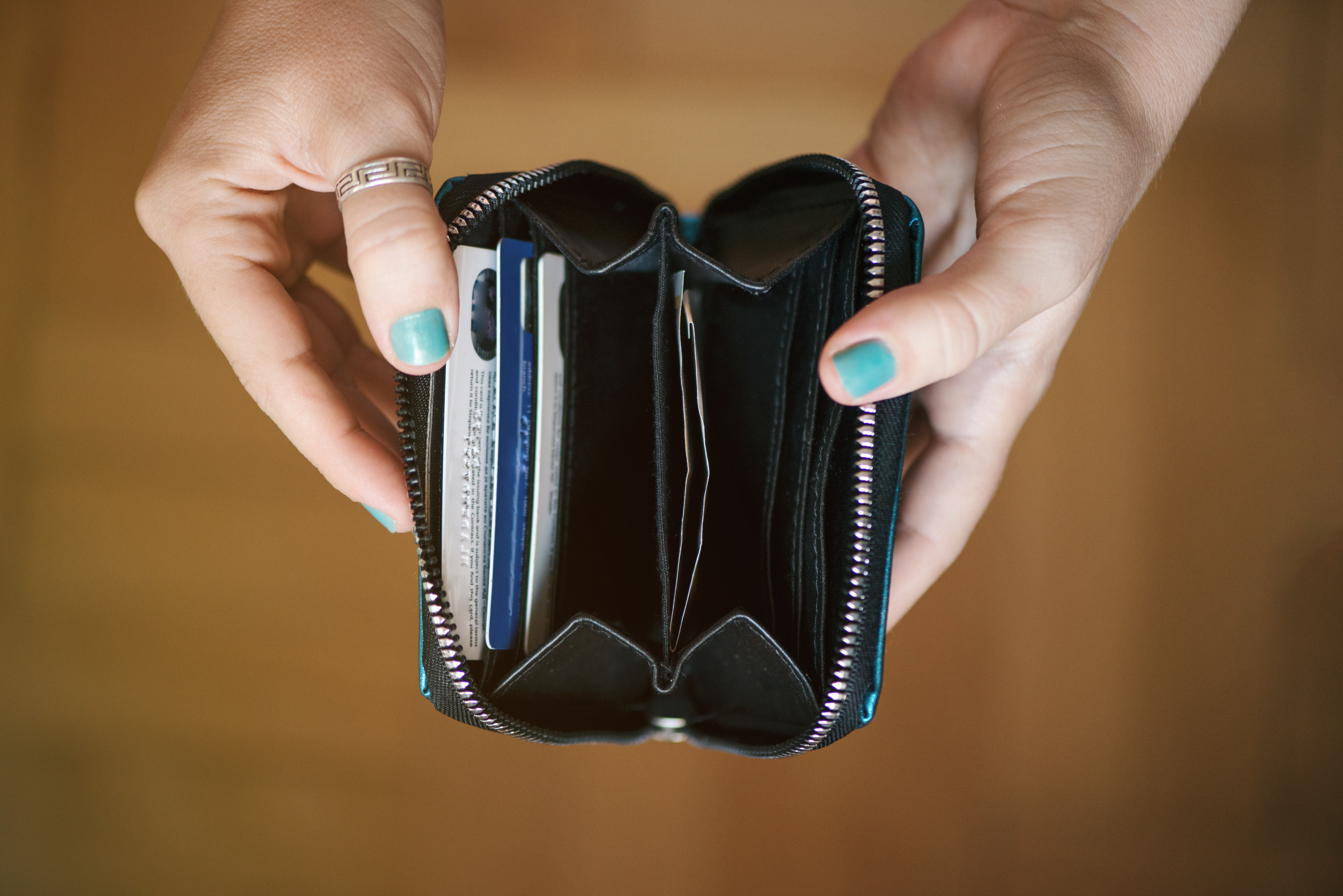 A woman holding an empty wallet | Source: Shutterstock