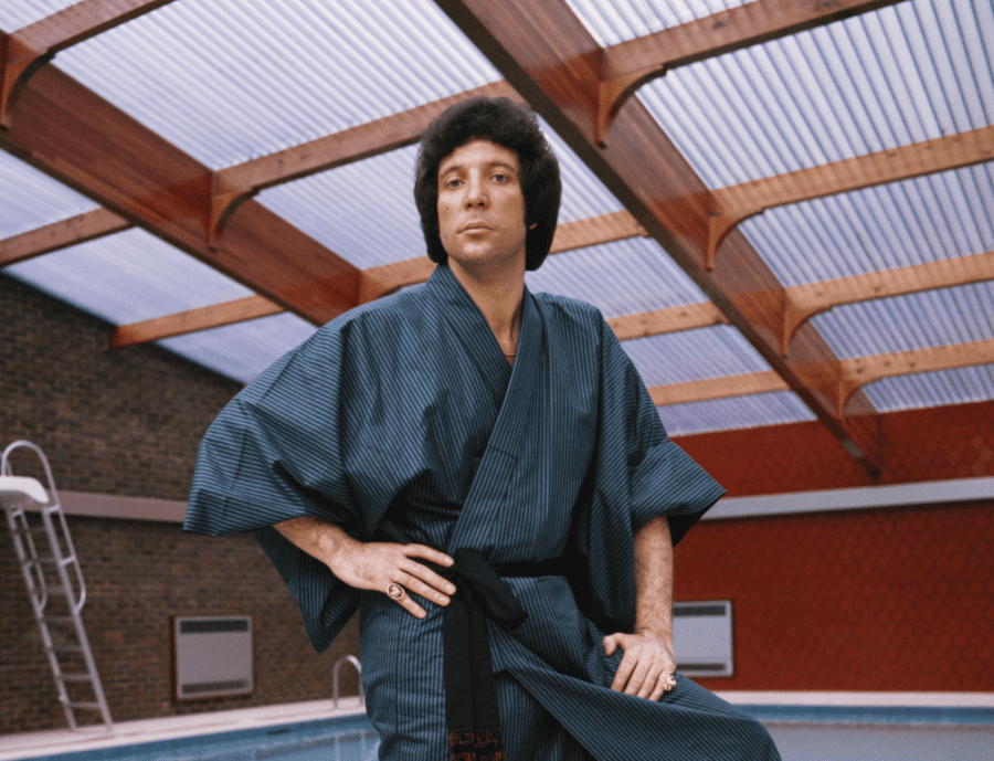 An undated image of Welsh singer and sex symbol Tom Jones standing by his swimming pool and wearing a robe at his home in St Georges Hill, near Weybridge | Source: Getty Images