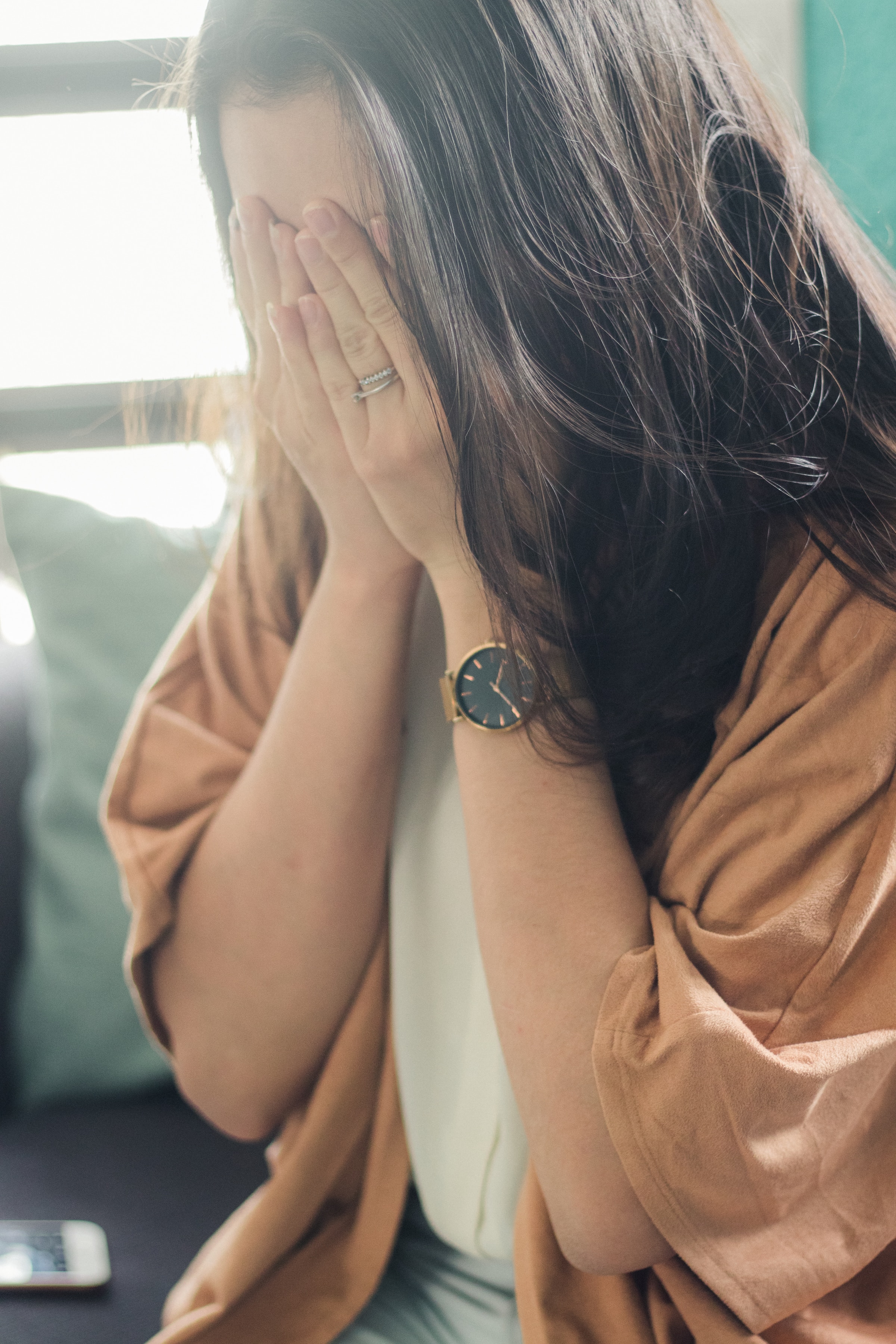 A woman covering her face with her hands | Source: Unsplash