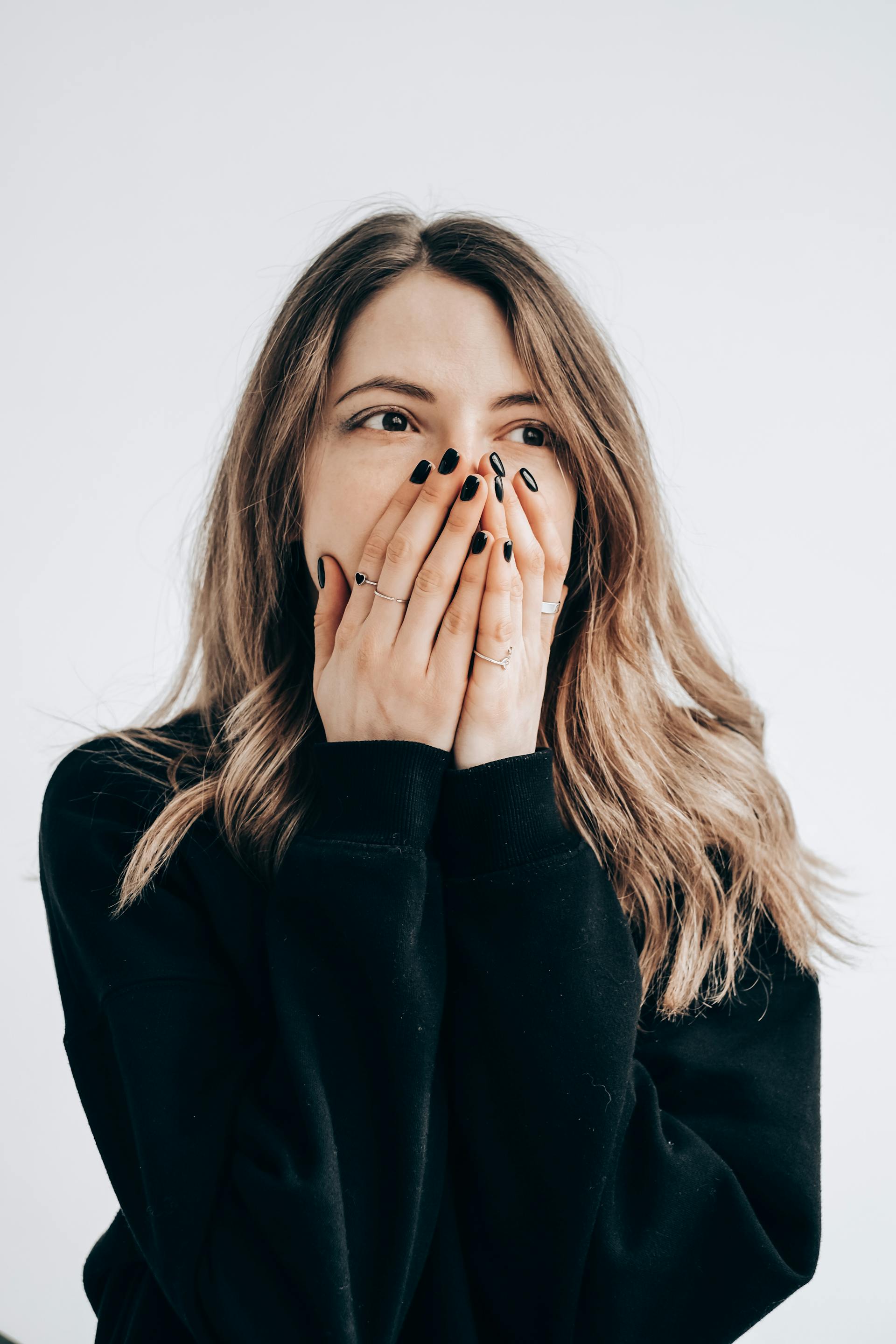 A shocked young woman covering her mouth | Source: Pexels