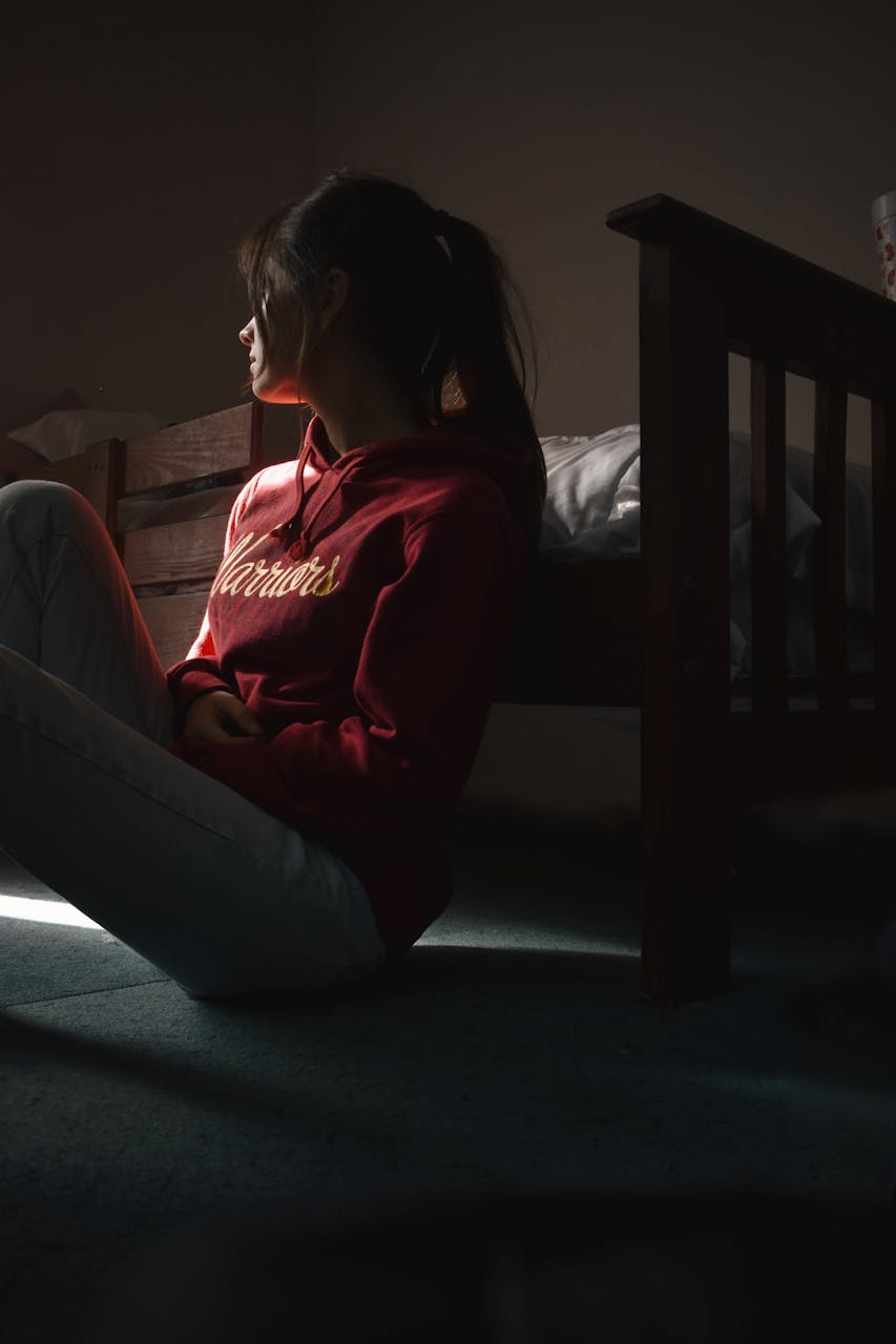 A sad young woman sitting on the floor | Source: Pexels