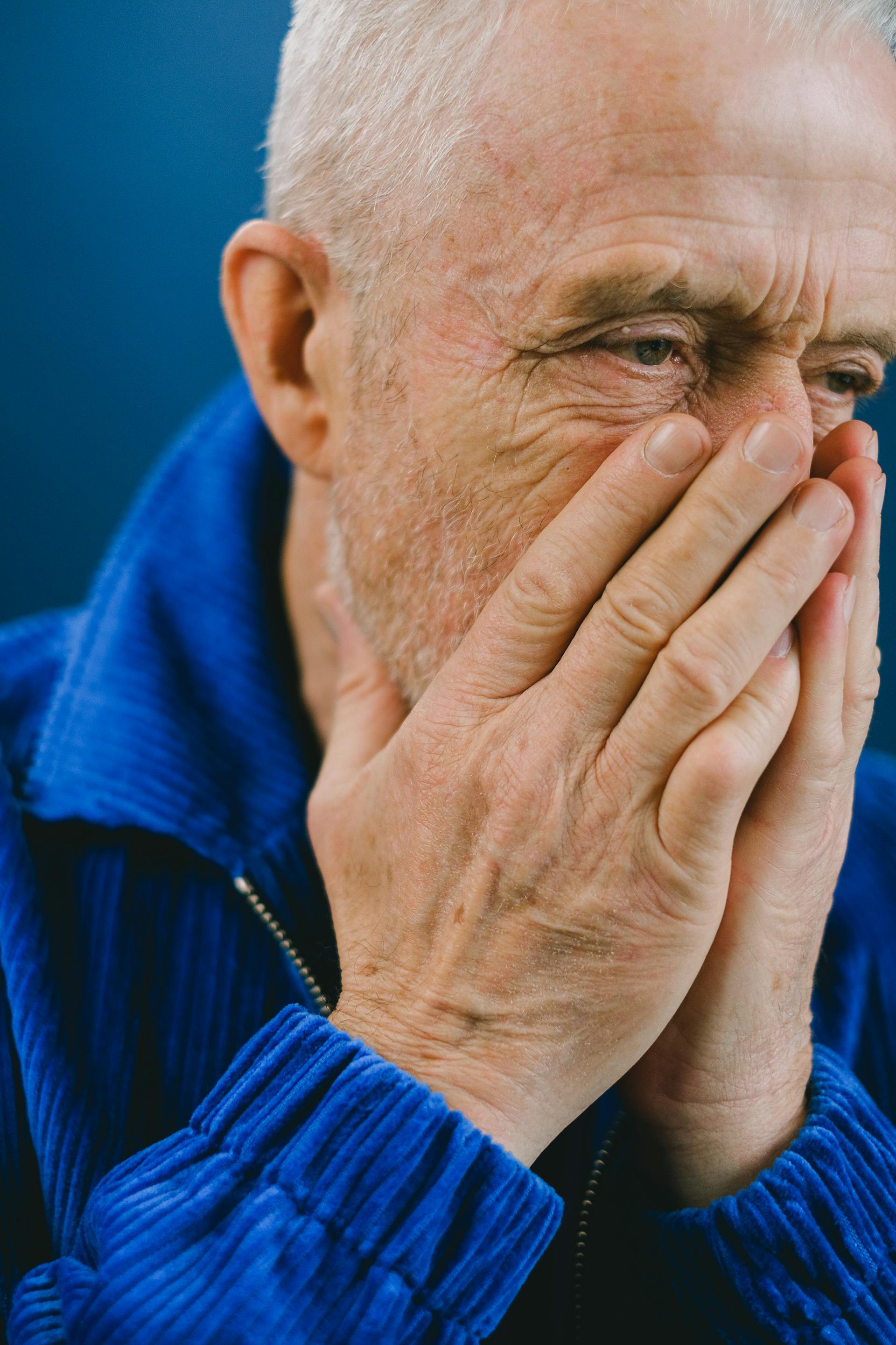 An upset senior man covering his mouth | Source: Pexels