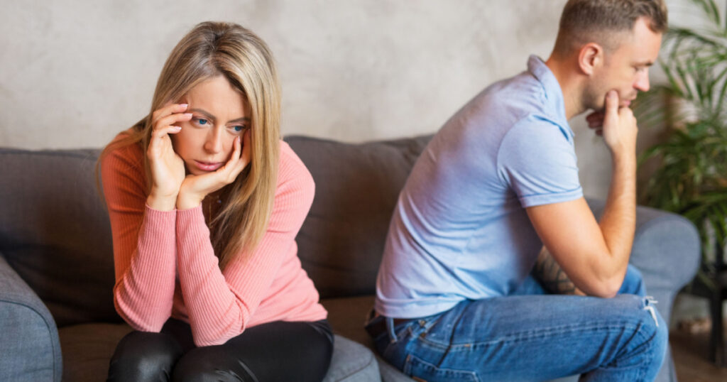 Sad couple sitting on couch
