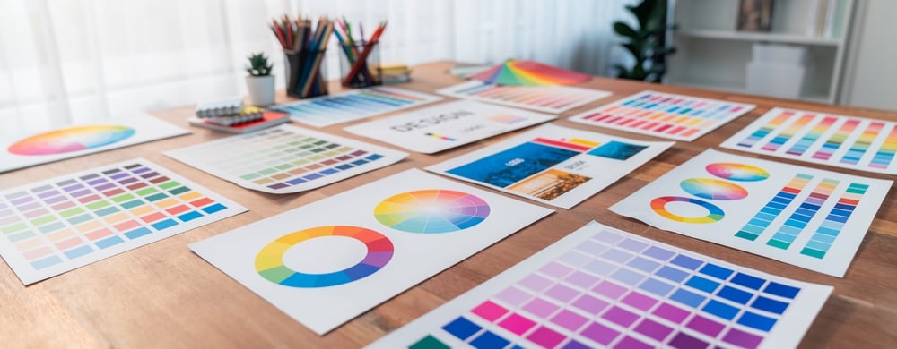 Panorama shot of various color palette idea papers arranged neatly on workspace table for graphic design concept. Color swatches and selection for unique digital art design. Scrutinize