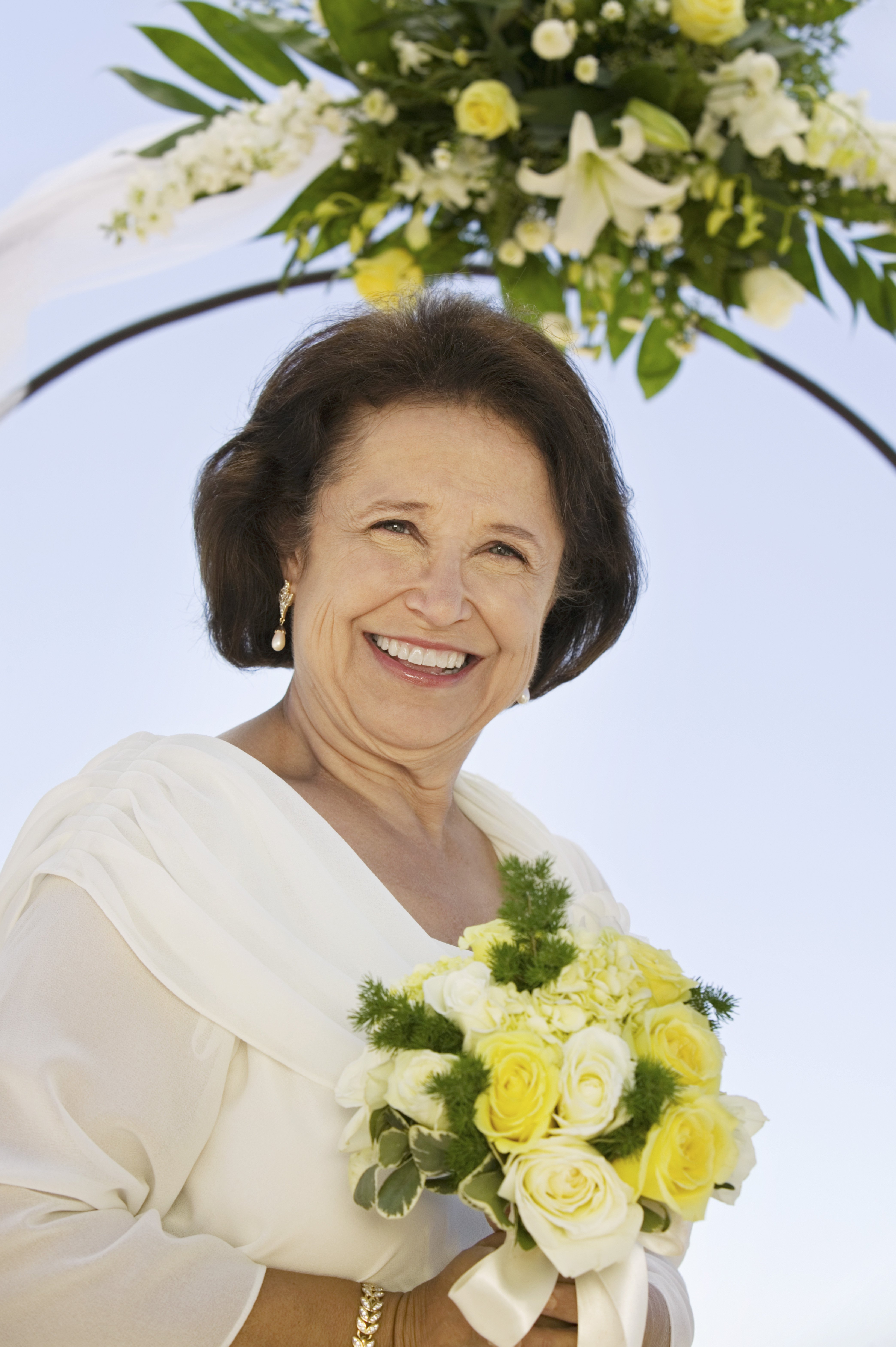 An elderly woman holding a bouquet | Source: Shutterstock