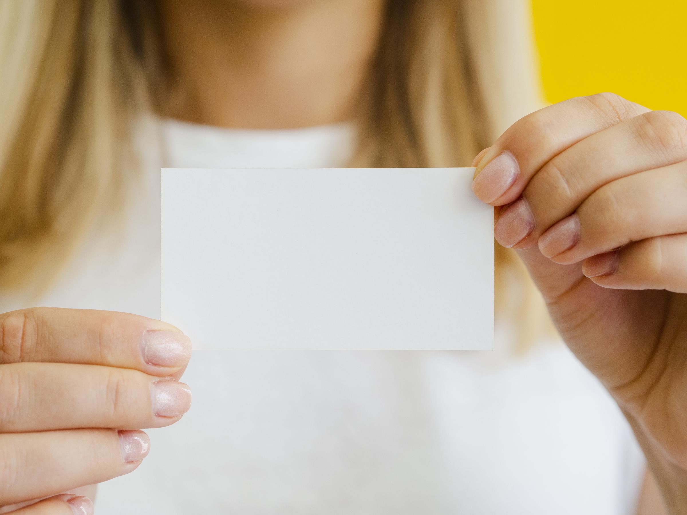 A woman holding a business card | Source: Freepik