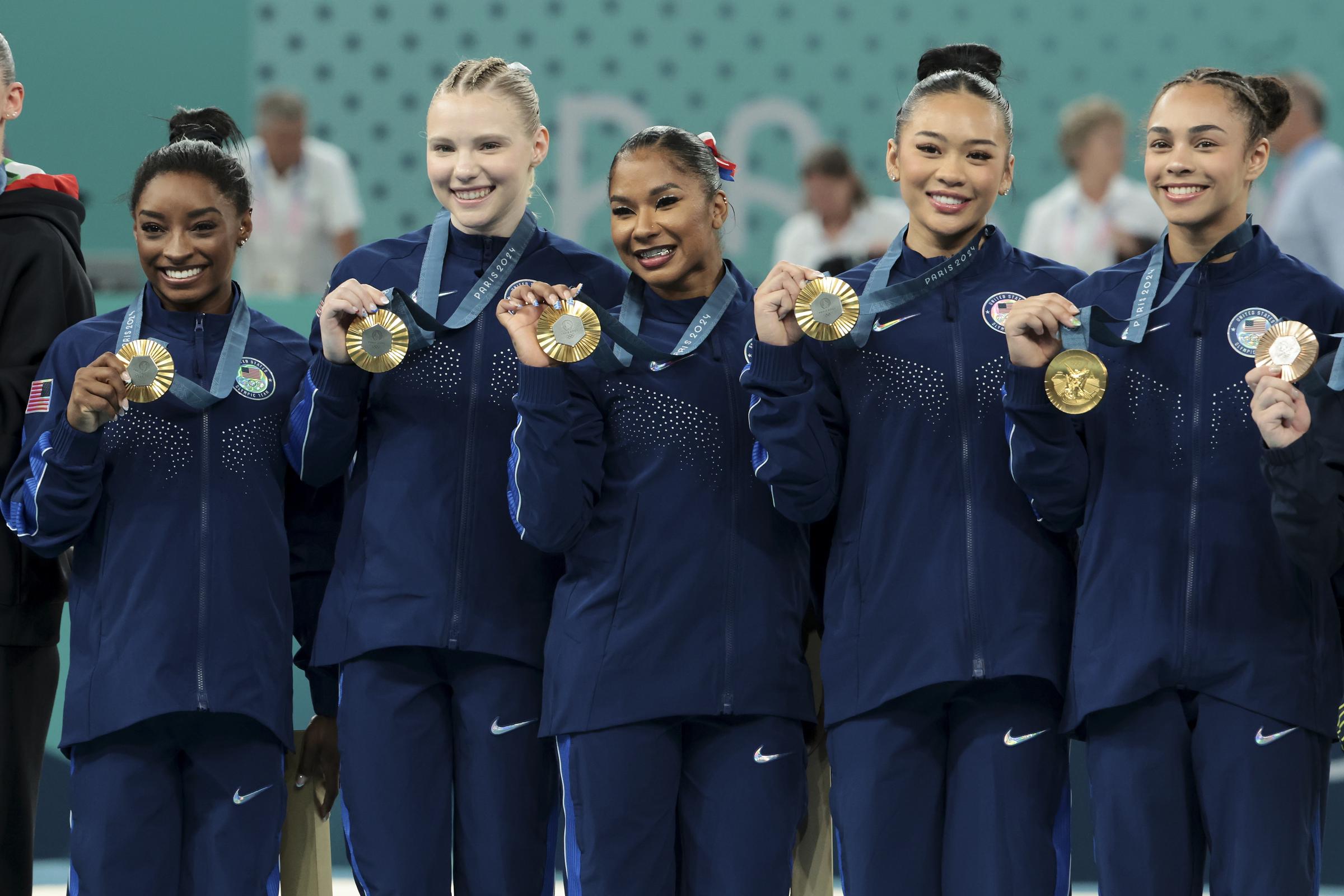 Gold medalists Simone Biles, Jade Carey, Jordan Chiles, Sunisa Lee, and Hezly Rivera celebrate on the podium during the Artistic Gymnastics Women's Team Final at the Paris 2024 Olympics on July 30, 2024 | Source: Getty Images