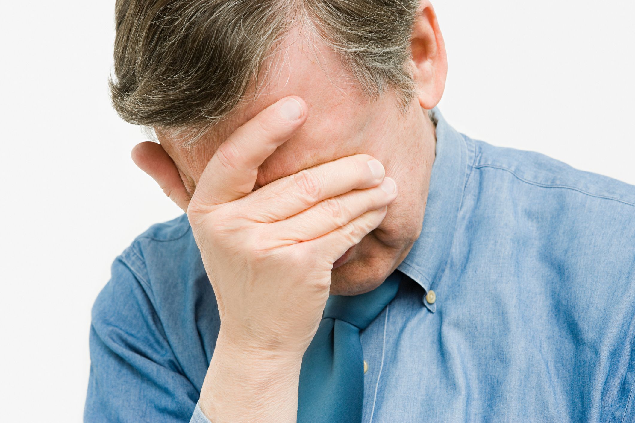 A man with his hand covering his face | Source: Getty Images