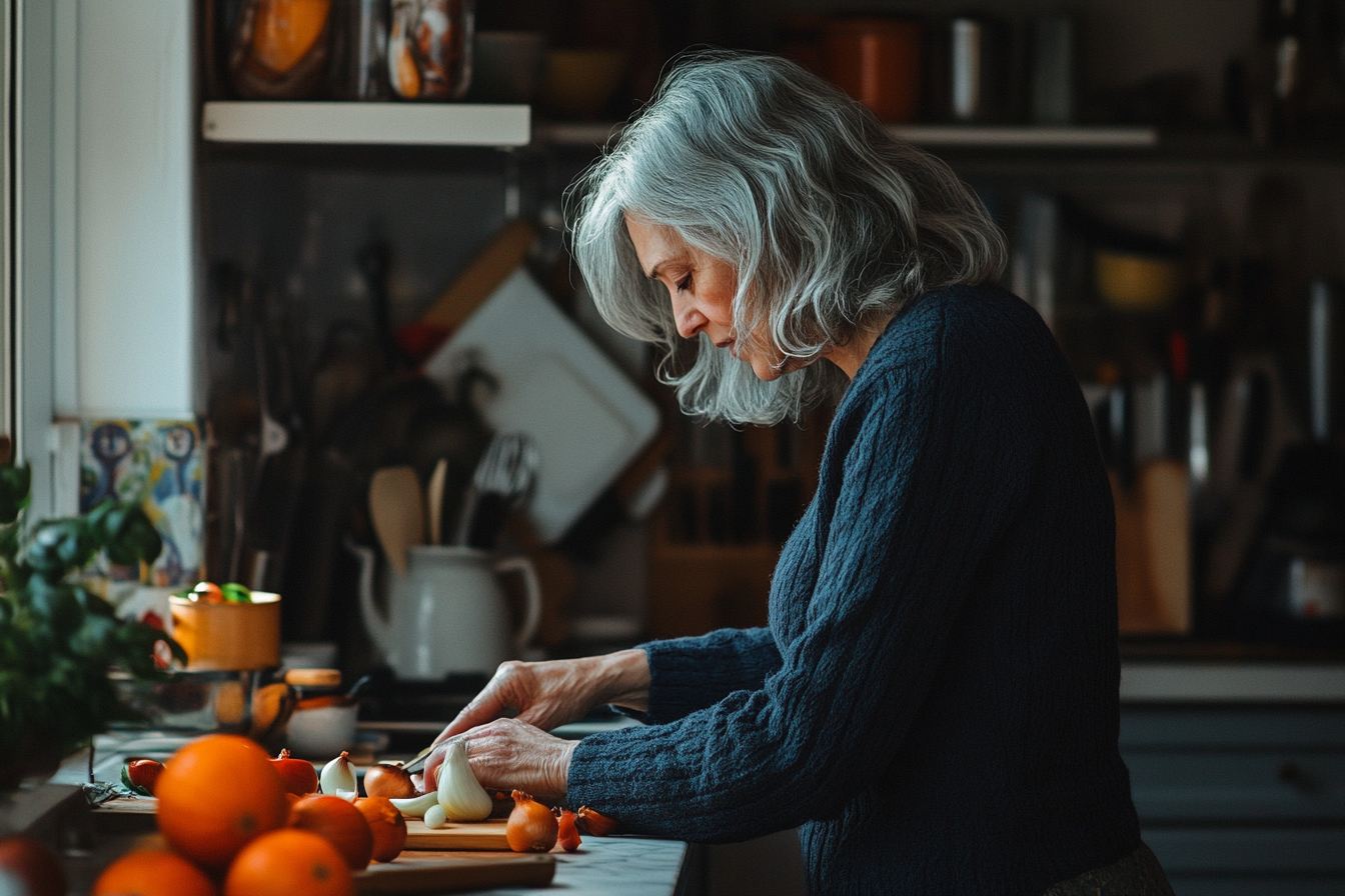 Woman in her 50s in the kitchen cutting ingredients with concentration | Source: Midjourney