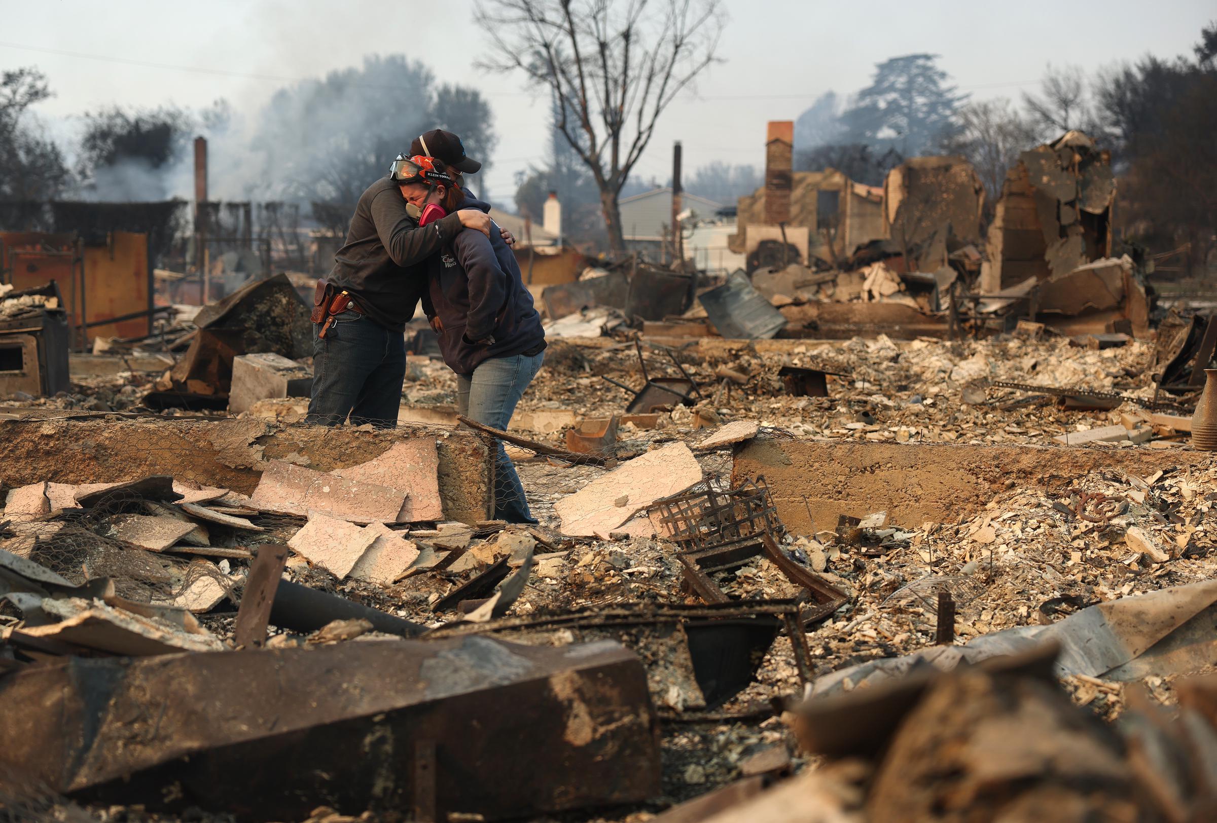 Khaled Fouad (L) and Mimi Laine (R) embrace as they inspect a family member's property that was destroyed by Eaton Fire on January 9, 2025, in Altadena, California | Source: Getty Images