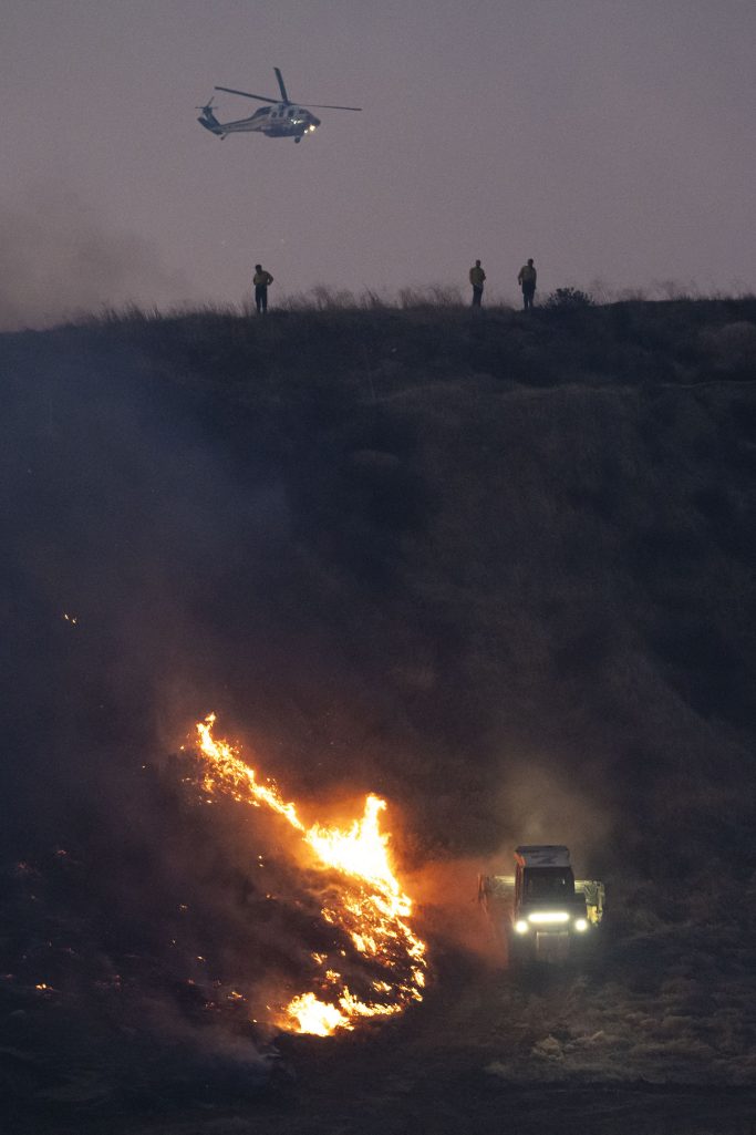 Cal Firefighters watch as a dozer tackles the Hughes Fire in California on January 22, 2025 | Source: Getty Images