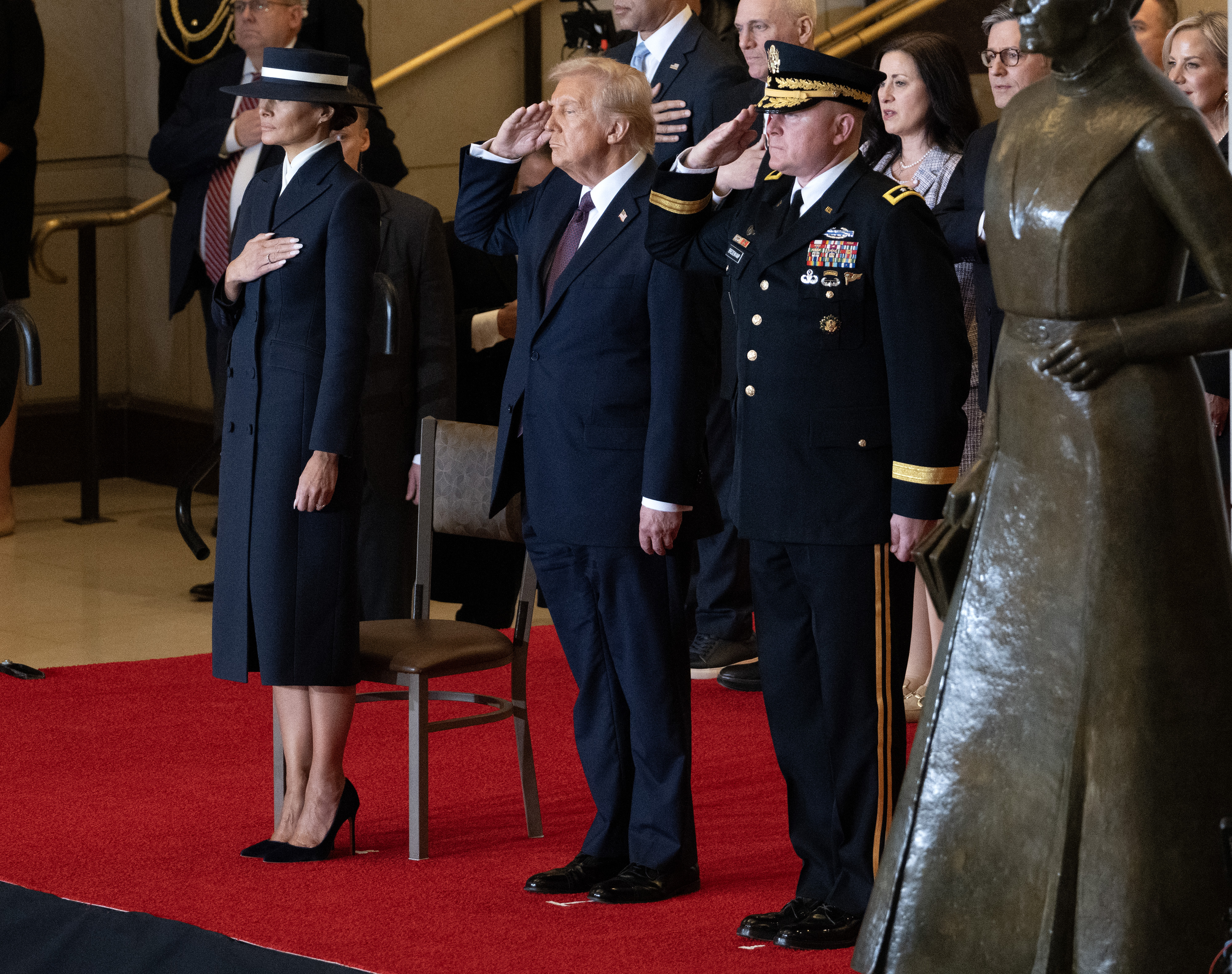 Melania Trump with her hand on her chest and Donald Trump saluting during the Reviewing the Troops Ceremony. | Source: Getty Images