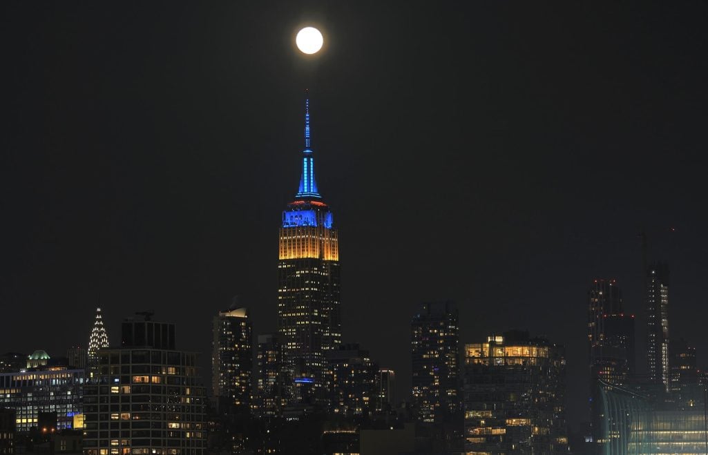 The full Snow Moon rises above the Empire State Building lit in the colors of the flag of Ukraine in New York City on February 24, 2024 | Source: Getty Images