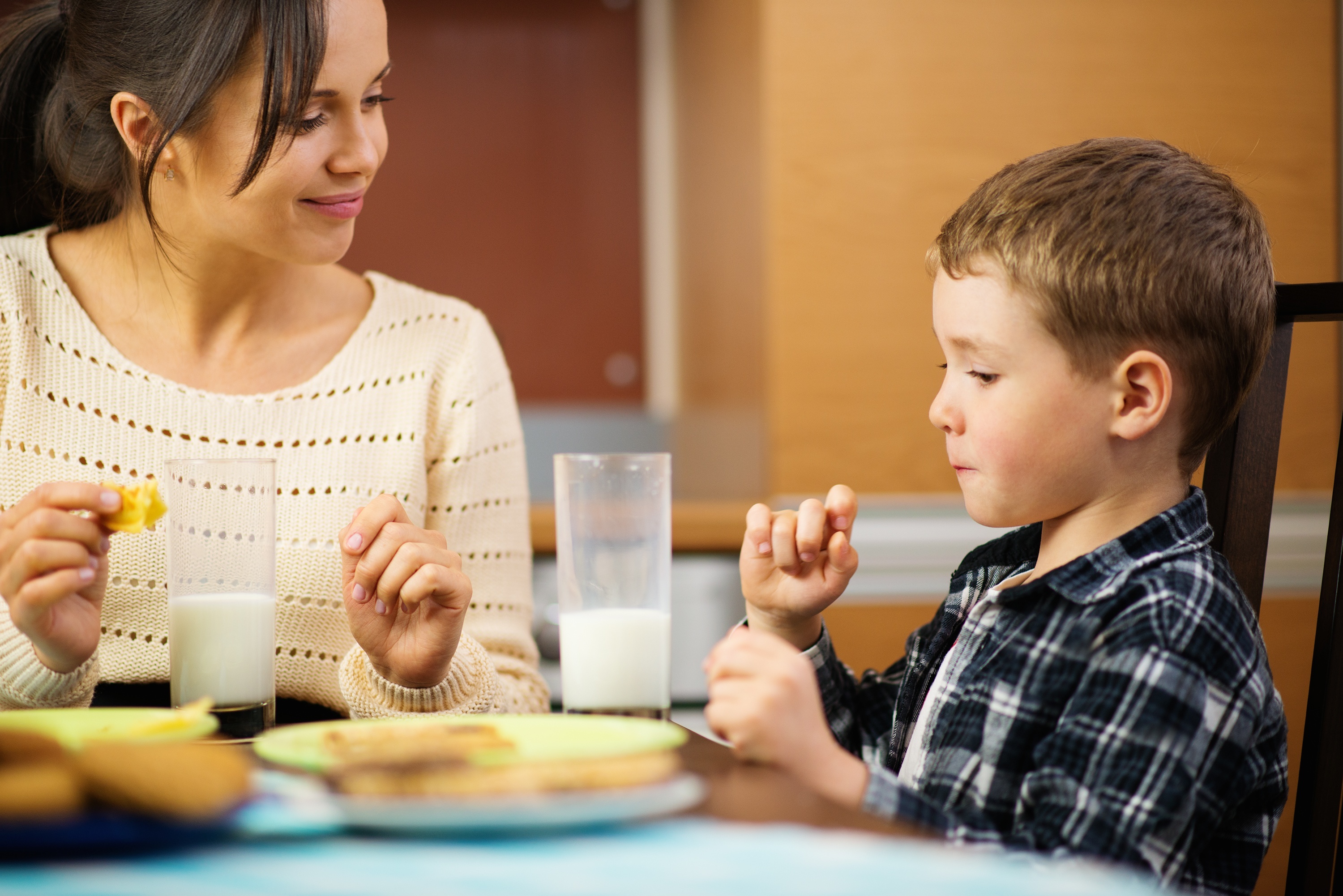 Young happy mother and her child eating. | Source: Shutterstock