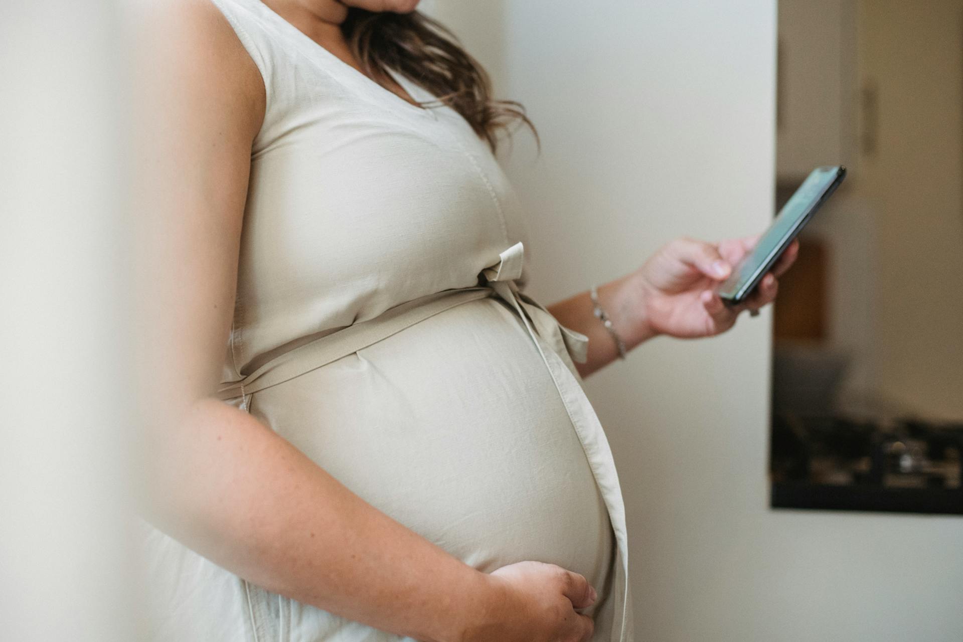 A pregnant woman looking at her phone | Source: Pexels