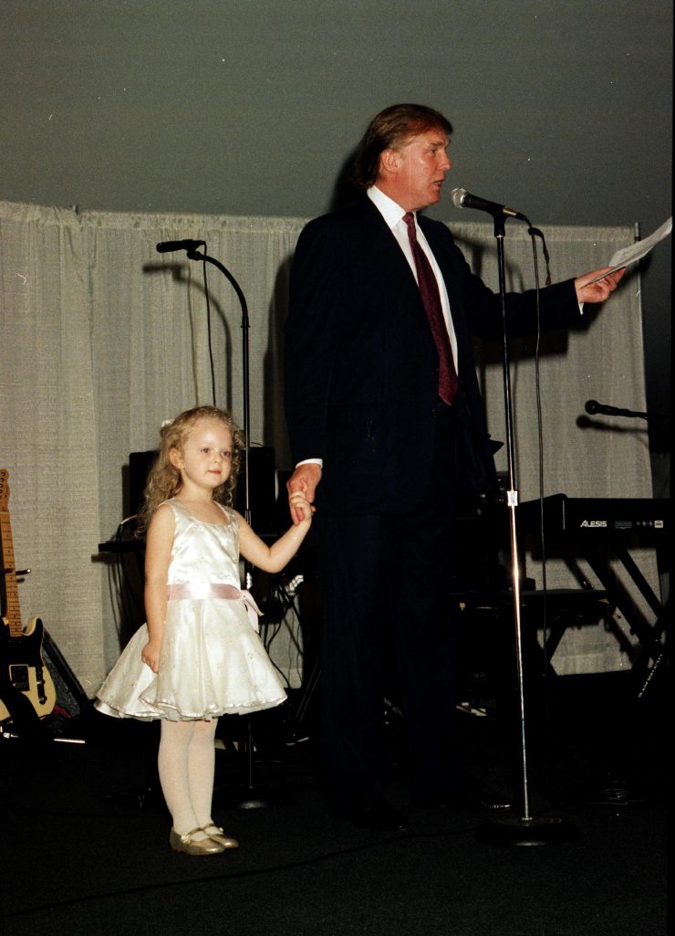 Donald Trump holding hands with his daughter while speaking onstage at the Mar-a-Lago club in Palm Beach, Florida, on February 22, 1997. | Source: Getty Images