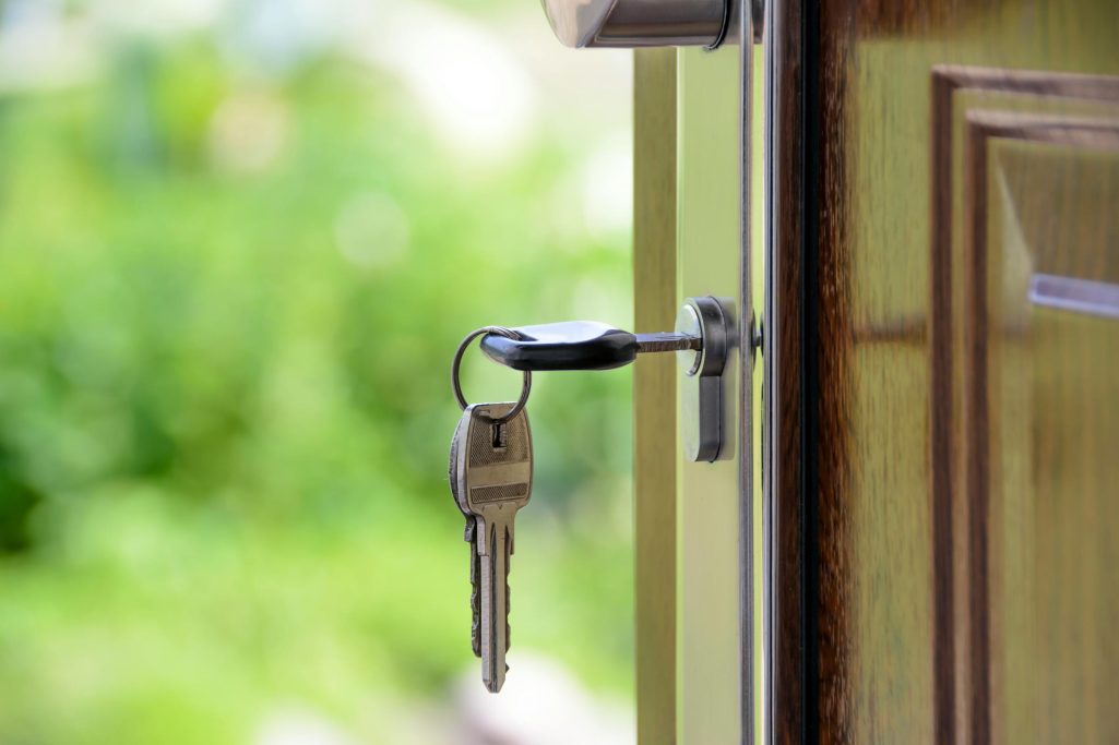 A key in the front door of a house with the door opening | Source: Pexels