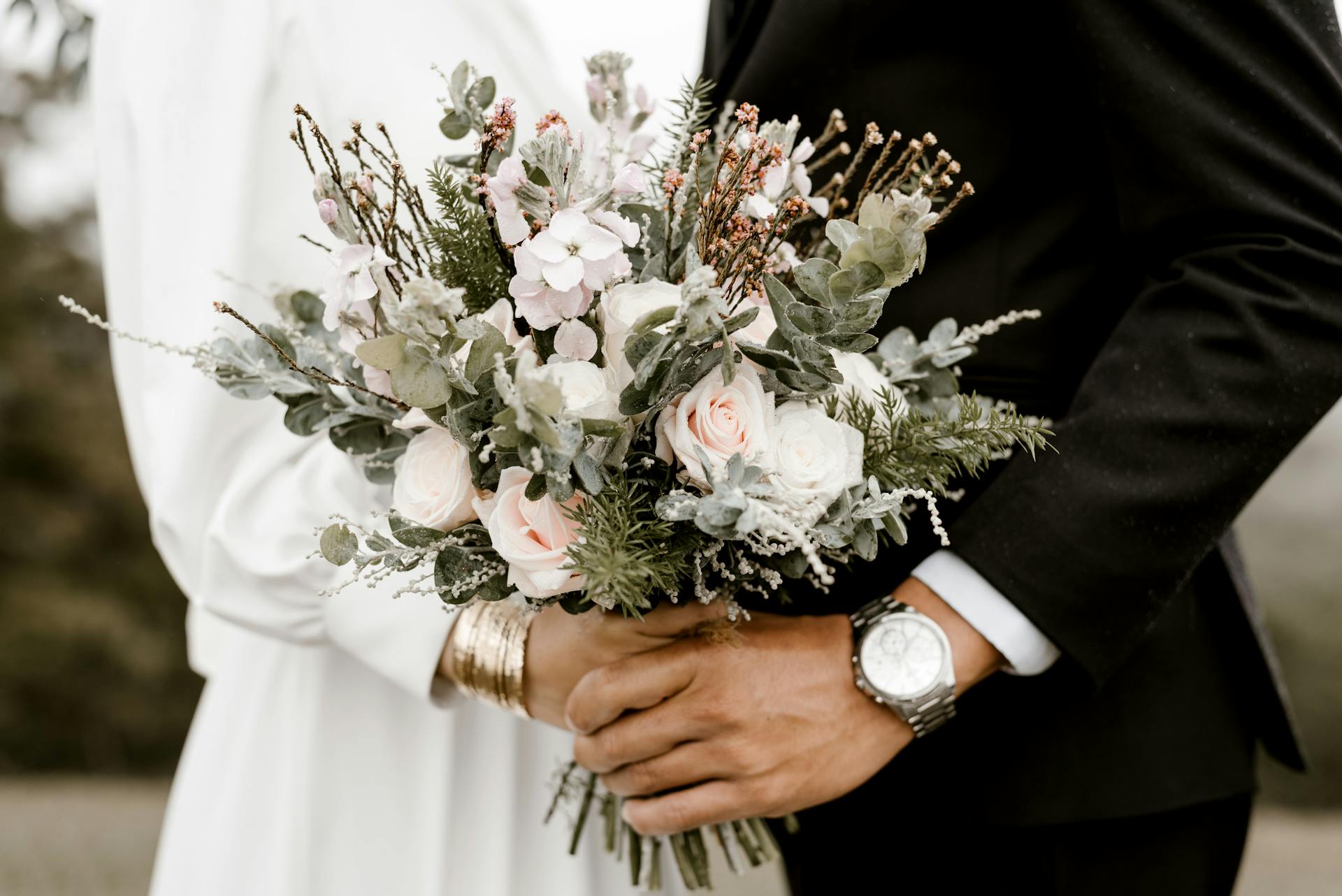 A couple holding flowers on their big day | Source: Pexels