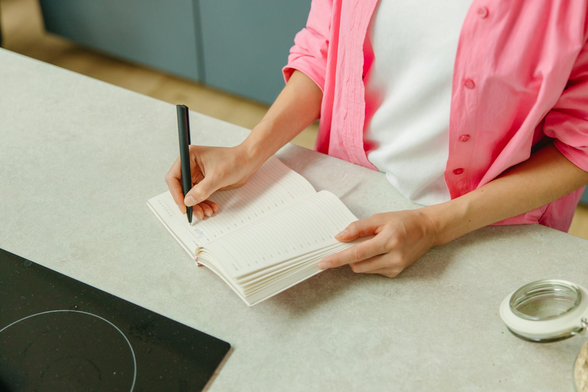 A closeup shot of a woman writing in a notebook | Source: Pexels