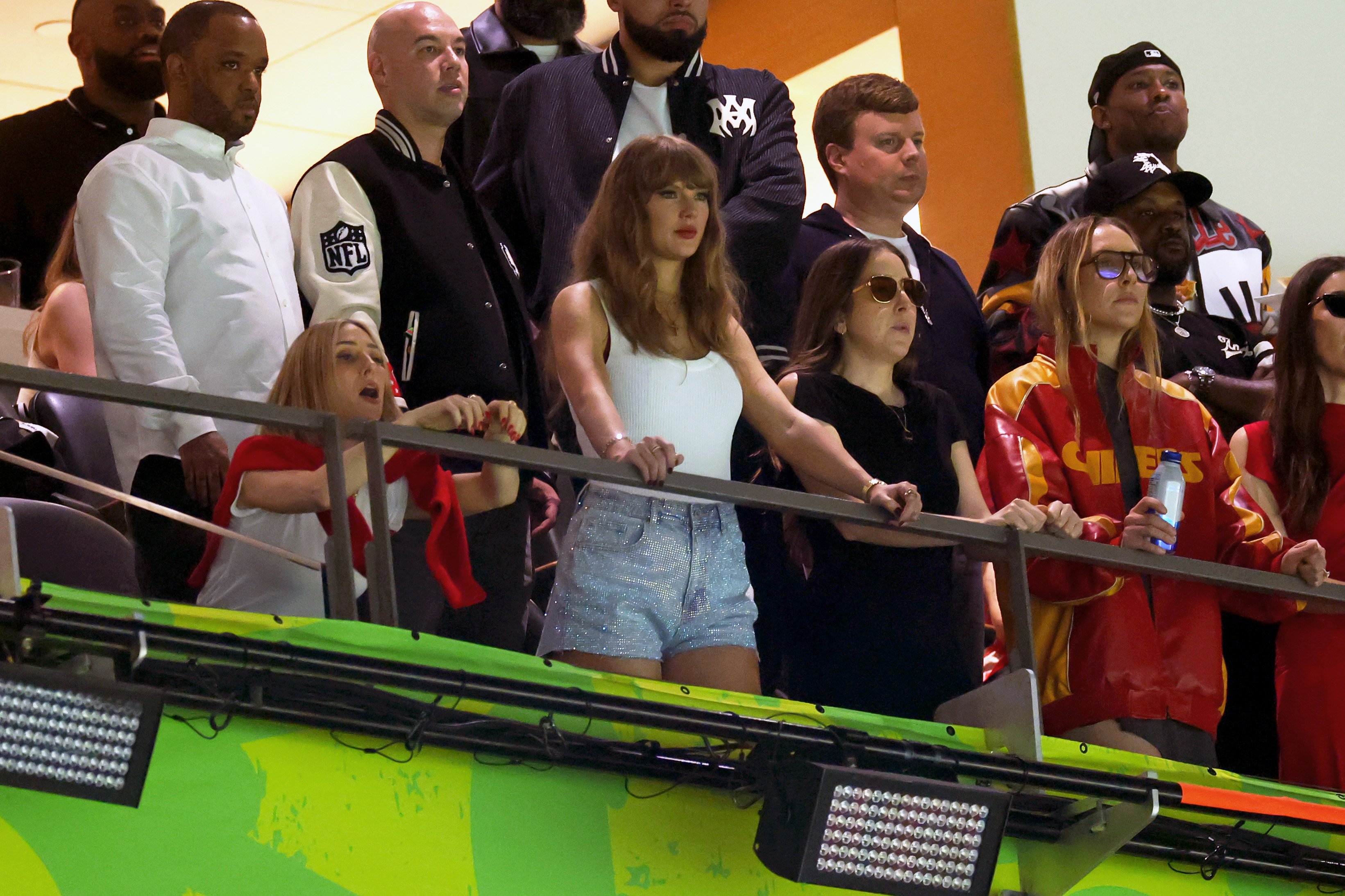 Taylor Swift holding onto a railing amid the Super Bowl crowd. | Source: Getty Images