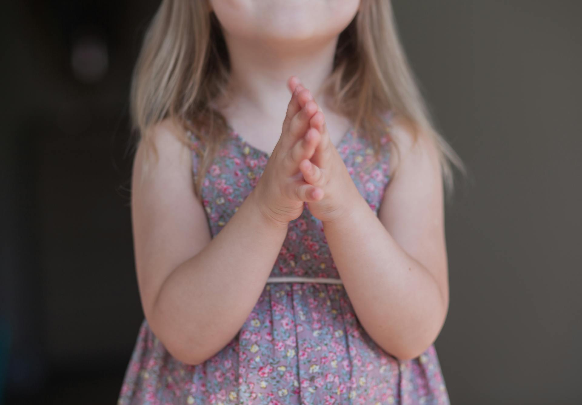 A little girl standing with her hands clasped together | Source: Pexels