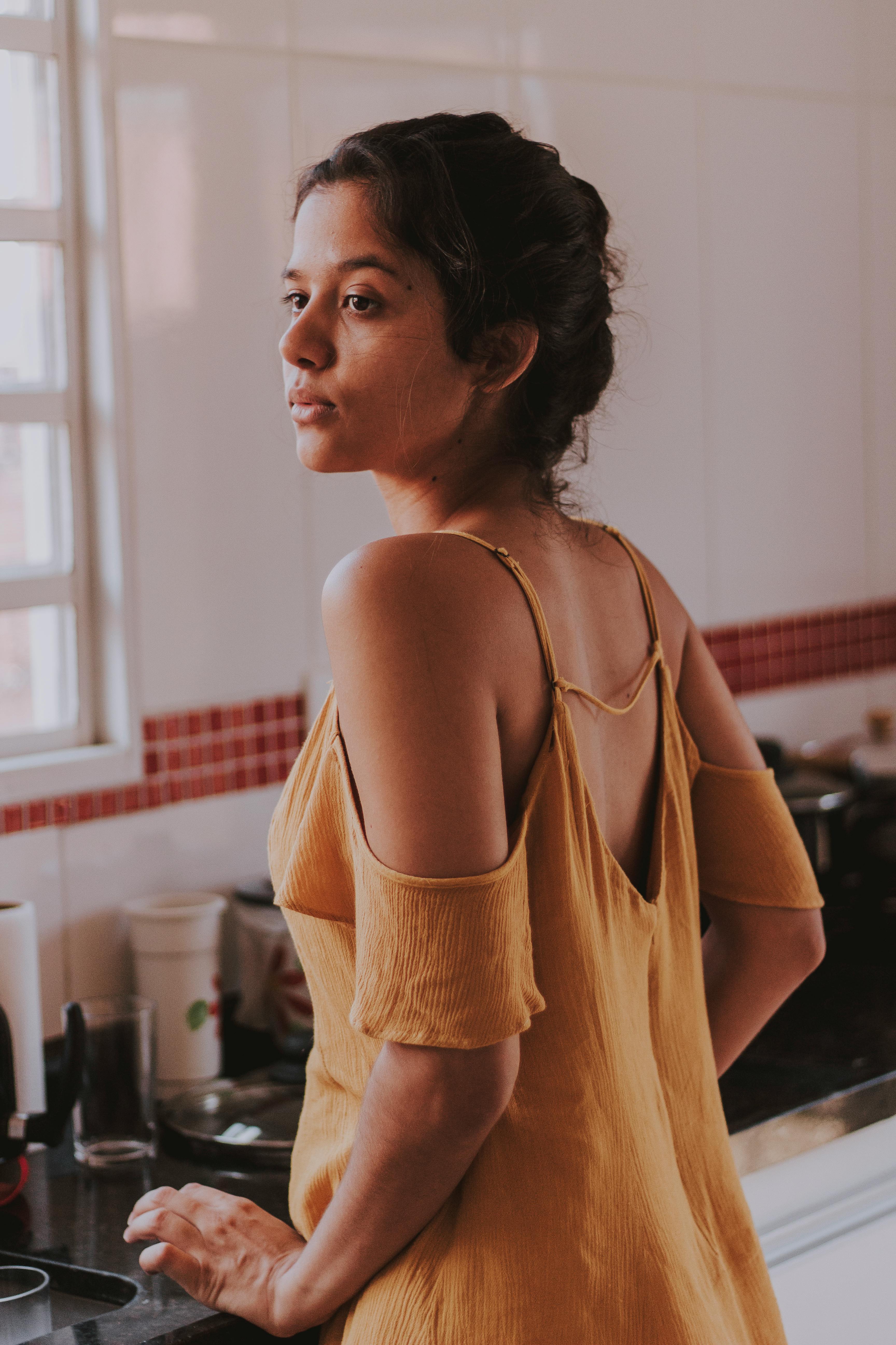 Woman in deep thought as she stands in front of the kitchen sink | Source: Pexels