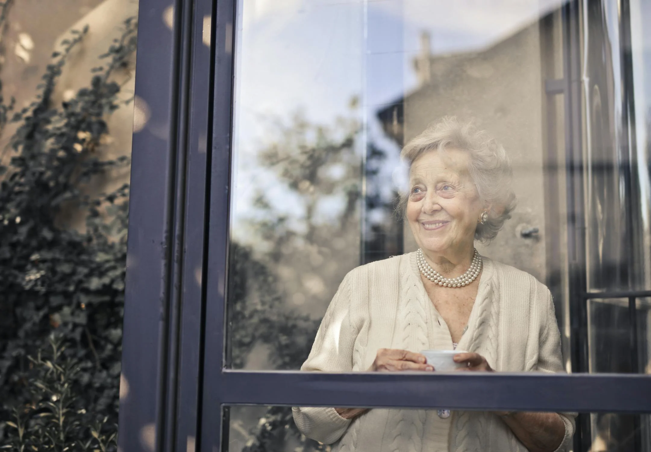 A smiling woman drinking a cup of tea ⏐ Source: Pexels